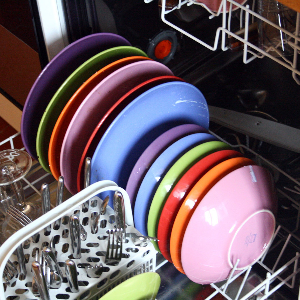 Colorful bowls and plates stacked in a dishwasher